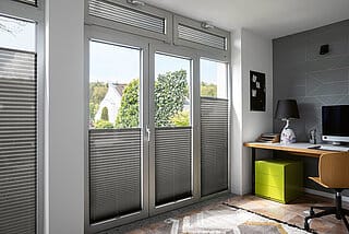 Blendschutz am Arbeitsplatz durch dunkles Plissees an Fenster und TĂźren