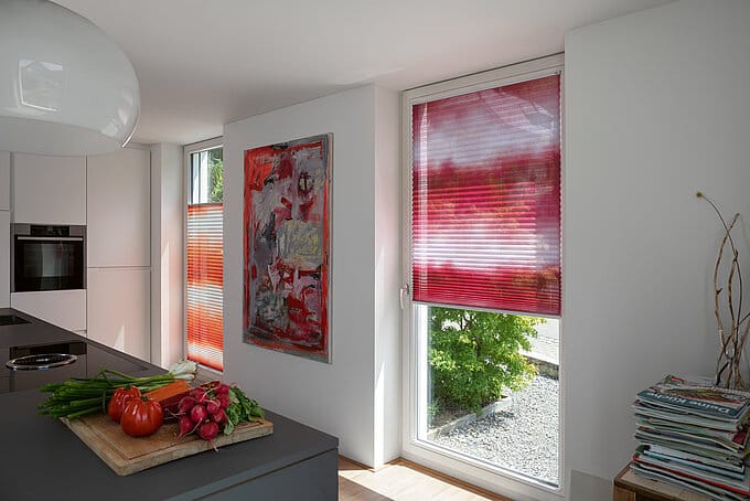 Senkrechte Plissees in Rot und Orange in einer KĂźche