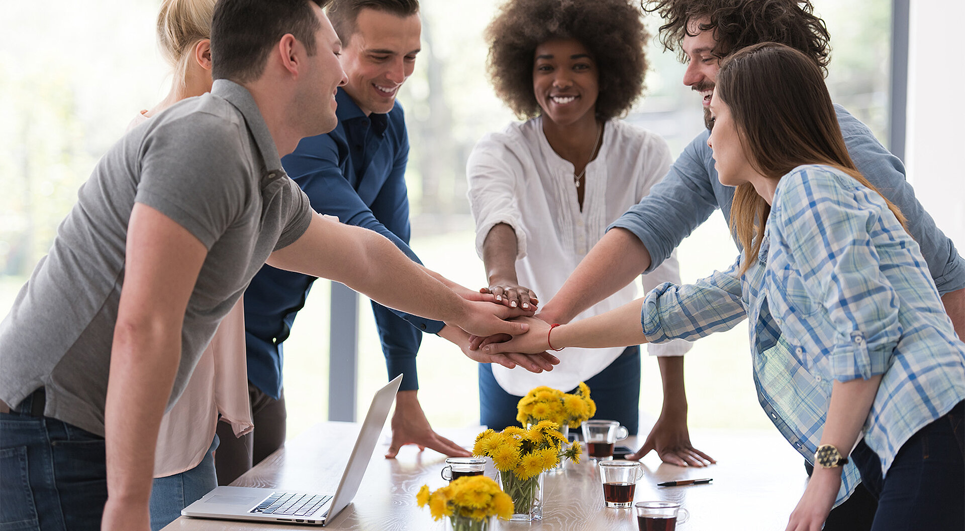 Fünf Personen als Team um einen Besprechungstisch