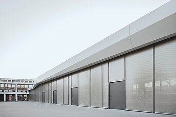 Gebäude mit grossflächigem aussenliegendem Sonnenschutzsystem s_enn und metallischem Behang zur Fassadenverschattung