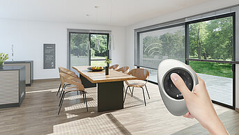 Wohnraum mit grossen Fenstern und Jalousien, die per Handfernbedienung gesteuert werden – Blick auf einen Esstisch und Garten.