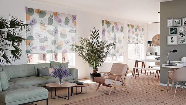 Wohnzimmer mit floral bedruckten Plissees im Motiv Irma vor grossen Fenstern, helle und moderne Raumgestaltung mit skandinavischem Flair